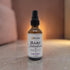 A bottle of Lavender Bare Intentions Massage Oil on a granite counter.