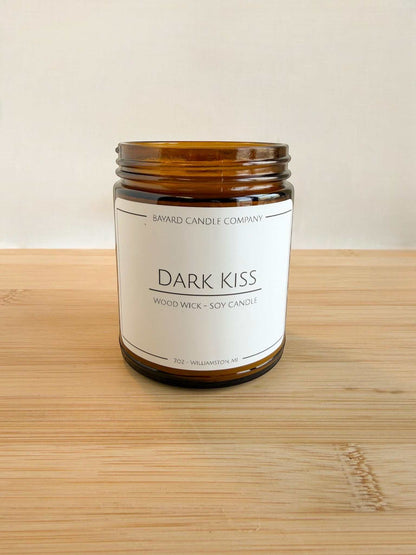 Dark Kiss soy candle in amber jar with clean label and minimalist background on wood surface