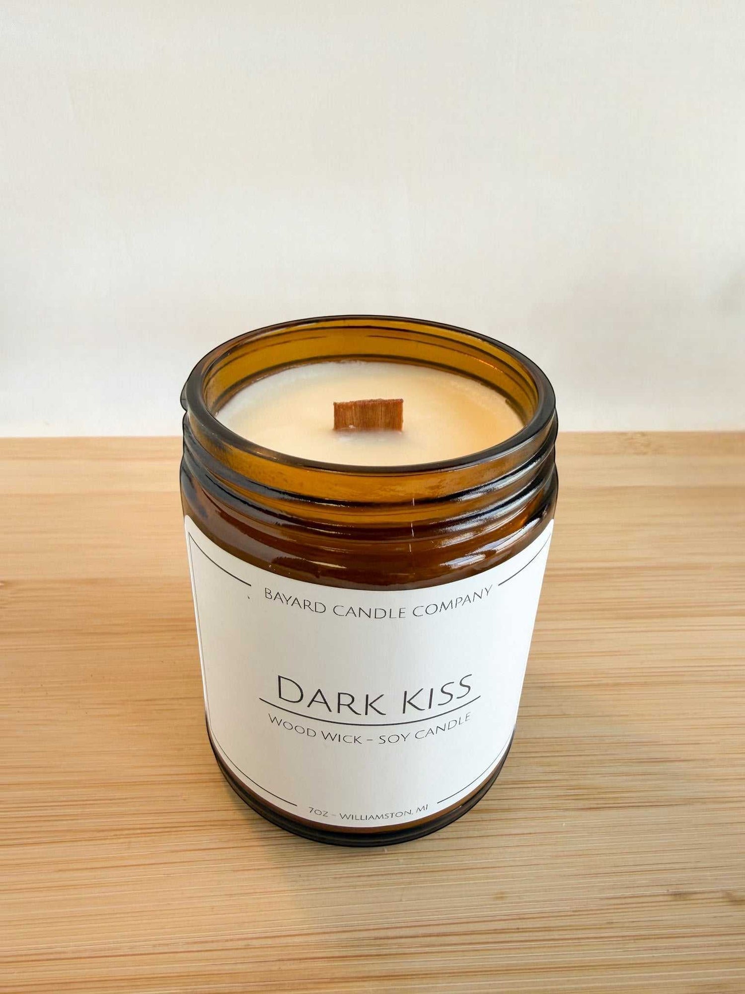 Top view of Dark Kiss wood wick candle showing natural soy wax and wooden wick inside amber jar