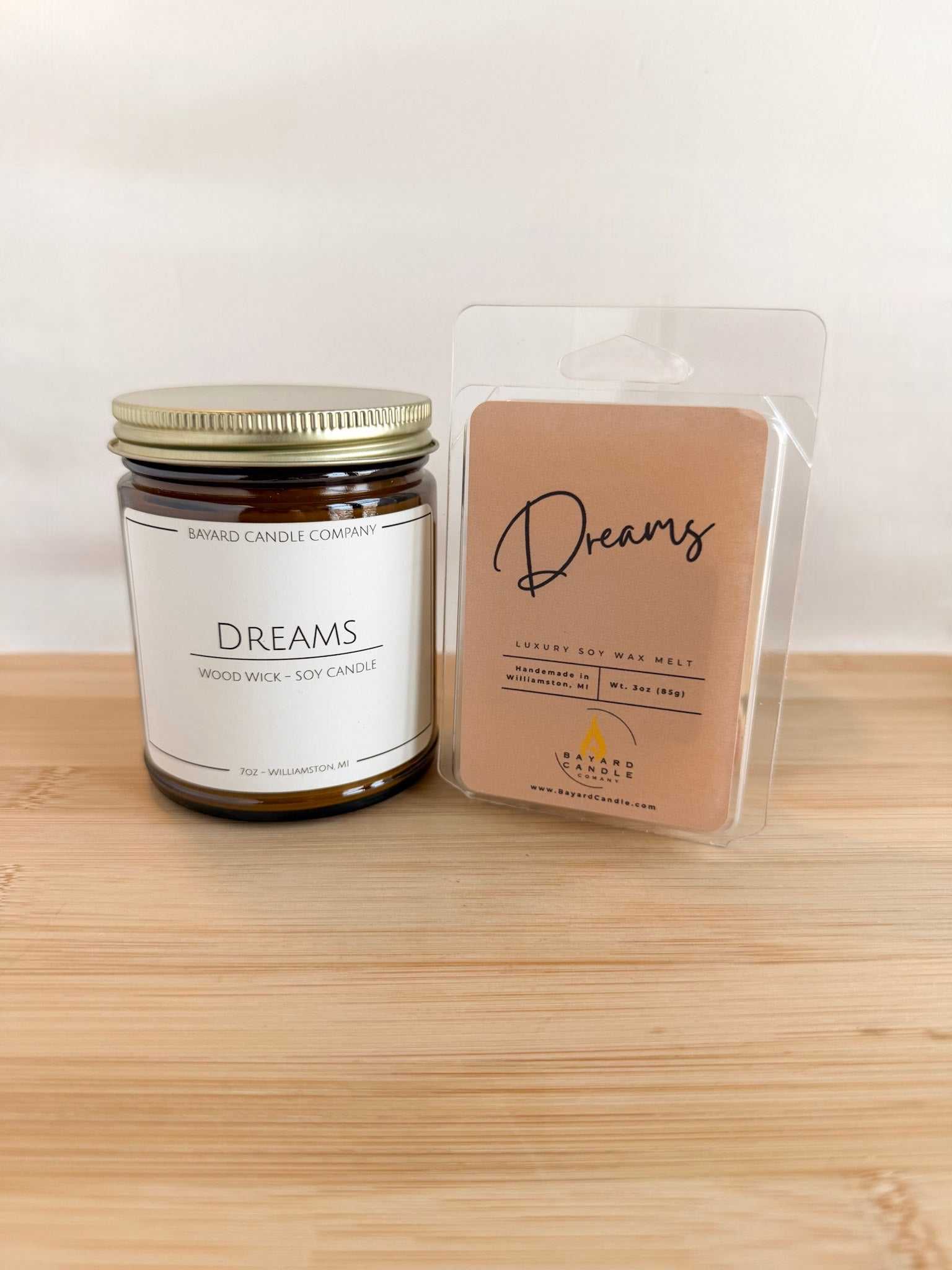 Dreams soy candle with matching wax melt, amber jar candle and scented melt on wood surface