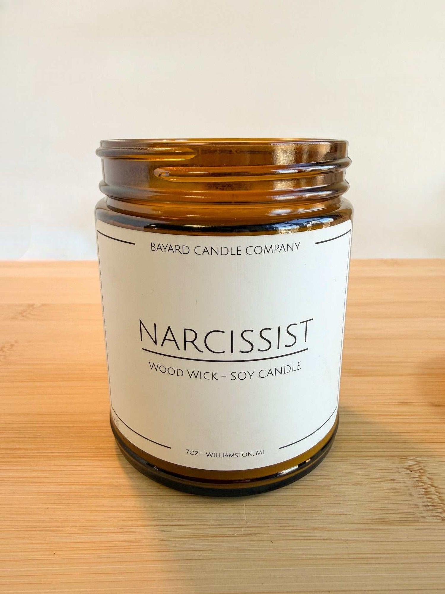 Narcissist wood wick soy candle with lid off showing natural soy wax and wood wick in amber jar