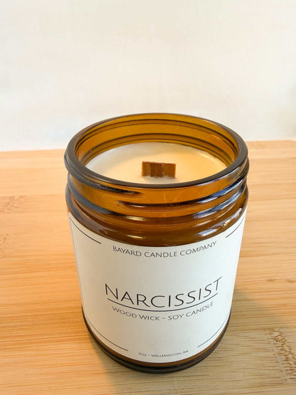 Top view of Narcissist wood wick candle showing smooth soy wax and wooden wick in amber jar