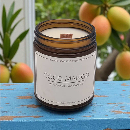 Coco Mango Wood Wick Candle on a blue table.