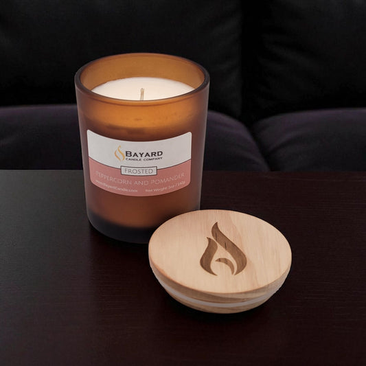 Frosted Peppercorn and Pomander Soy Candle on a dark table