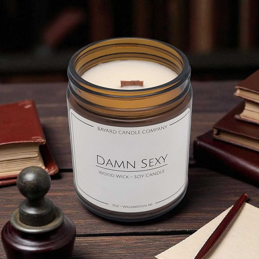 Damn Sexy Wood Wick Candle on an explorers desk