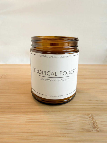 Tropical Forest wood wick soy candle in amber jar with lid off,