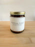 Tropical Forest wood wick soy candle in amber glass jar with gold lid on wood surface, clean background