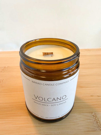Volcano wood wick soy candle in amber glass jar without lid on showing woodwick wood surface, bright clean aesthetic